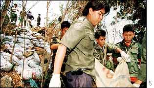 Thai charity workers carry one of 13 dead bodies from a waste site in Prachinburi province