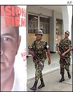 Soldiers pass by campaign posters for Senate candidate German Vargas in Florencia, southern Colombia