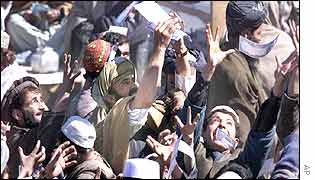 Afghans in Kabul grab notices offering a reward for information on al-Qaeda