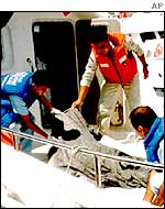 Turkish coastguards cover the body of an asylum-seeker who died trying to reach Greece from Turkey