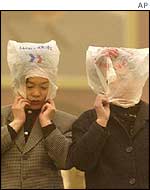 Chinese women wearing plastic bags to protect their hair and faces