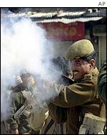 policeman firing teargas in Srinagar