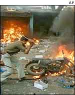 A rioter destroys property in Gujarat