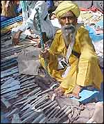 A Sikh vendor sells knives and daggers at the fair