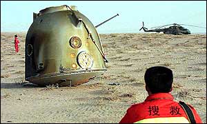 Chinese security personnel surround the unmanned spacecraft Shenzhou III which landed in Inner Mongolia