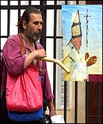 A worker walks past a poster advertising the Pope's impending visit in Sofia 