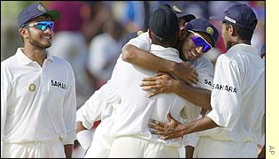 Rahul Dravid of India congratulates bowler Harbhajan Singh after he took the wicket of Ridley Jacobs
