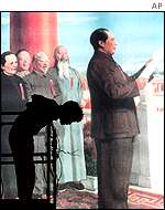 A workmen erects a huge poster of former leader Mao Zedong