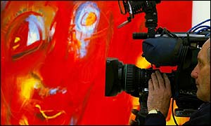 Cameraman filming McCartney painting