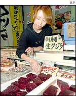 Japanese saleswoman arranges whale meat