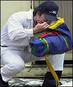A member of the Taiwan Coast Guard checks a piece of luggage found off the coast of the Taiwan island Penghu