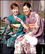 Young Japanese women aged 20 in traditional kimono dresses have a smoke after their coming of age ceremony