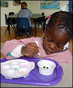 girl transfers beads with a pair of tweezers