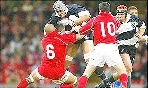 Kieran Roche of the Barbarians is tackled by Gavin Thomas of Wales 