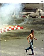 Protester runs to avoid tear gas in Tizi Ouzou