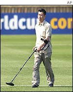 A man examines a pitch with a metal detector