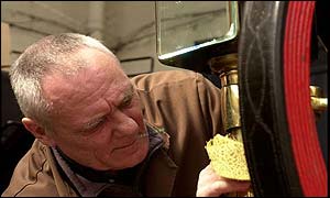 Carriage cleaner Richard Borer buffs up a wheel of a state landau