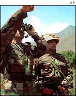 Pakistan army soldiers monitor the positions of Indian troops in mountains along the line of control in Chakoti