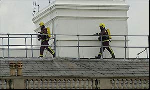 Firemen scour the roof top near the blaze