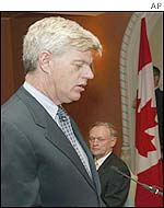 John Manley is sworn in as Finance Minister as Canadian Prime Minister Jean Chretien (right) looks on during a ceremony in Ottawa
