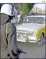 Police officers check cars entering Kabul for arms and other contraband