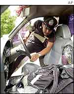 A police inspects the inside of the bullet-ridden vehicle 