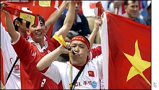 Chinese fans carrying flags and blowing on horns