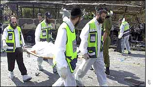 Paramedics carry away a body on a stretcher