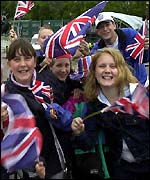 children wave flags at the procession