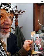 Yasser Arafat with photo of himself and daughter