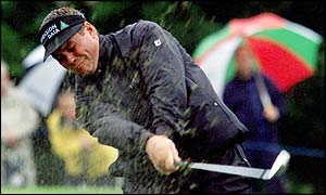 Clark forces the ball out of the bunker in terrible conditions for golf