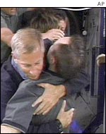 Astronauts embrace after opening the door to the ISS, AP