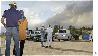 Larry Landis (left) puts his arm on the shoulder of his wife, Rea, as they watch the fire approach their new home west of Colorado Springs