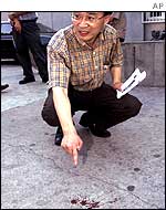 Lee Sang-min, journalist from South Korean news agency Yonhap, points at blood stains that he said resulted from the struggle 