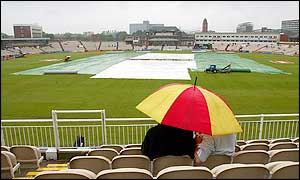 Spectators sit in the rain at Old Trafford