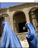 woman walk past a war-ravaged building