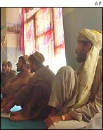 Afghans watch the live broadcast of the loya jirga
