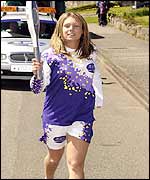 Welsh swimmer Llinos Hughes carries the Baton through Beaumaris, Wales