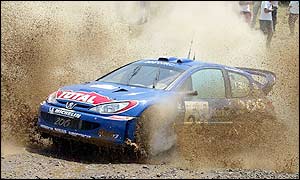 Gilles Panizzi and Herve Panizzi drive through the muddy waters of the Elatia stage on day two