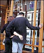 People looking in an estate agents window