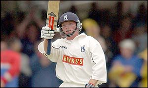 Warwickshire's Ian Bell lifts his bat to acknowledge the crowd after reaching his half-century