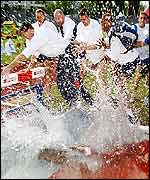 British team captain Dwain Chambers gets the traditional dunking in the steeplechase water jump