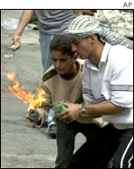 Palestinian youths light fire-bombs in Hebron