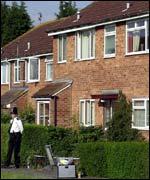 A police officer guards the house where the shooting happened