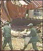 Rescue workers walk near wreckage