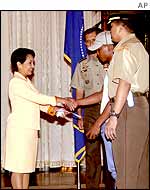 President Gloria Arroyo hands a cheque to the informant known as Gardo Ibrahim