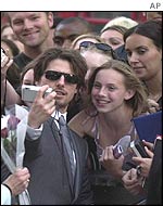 Tom Cruise takes a photo of himself with a fan