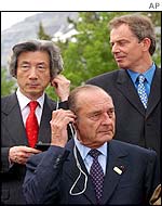 Japanese Prime Minister Junichiro Koizumi and French President Jacques Chirac adjust earpieces while British Prime Minister Tony Blair looks on