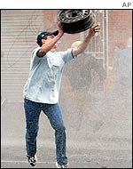 Protester aims a wheel hub at police