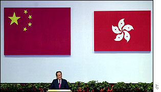 Jiang Zemin delivers a speech under the Chinese national flag, left, and the HK flag, right